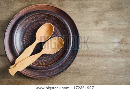 Rustic Kitchen Utensils: the Ceramic Plates and Wooden Cutlery on Wooden Background. Home Wares. Kitchen Decor in Rustic Style. View From Above With Copy Space.