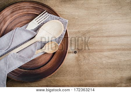 Rustic Kitchen Utensils: the Ceramic Plates and Wooden Cutlery on Wooden Background. Home Wares. Kitchen Decor in Rustic Style. View From Above With Copy Space.