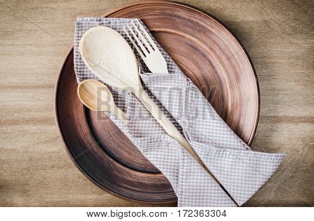 Rustic Kitchen Utensils: the Ceramic Plates and Wooden Cutlery on Wooden Background. Home Wares. Kitchen Decor in Rustic Style. View From Above With Copy Space.