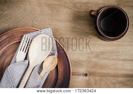 Rustic Kitchen Utensils: the Ceramic Plates and Wooden Cutlery on Wooden Background. Home Wares. Kitchen Decor in Rustic Style. View From Above With Copy Space.