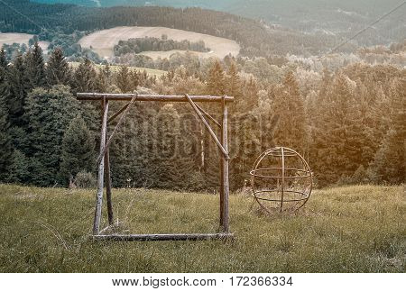 Dreamy abandoned playground with overgrown grass in the forest in warm colours, nostalgic lonelines abandonment neglect, lost childhood