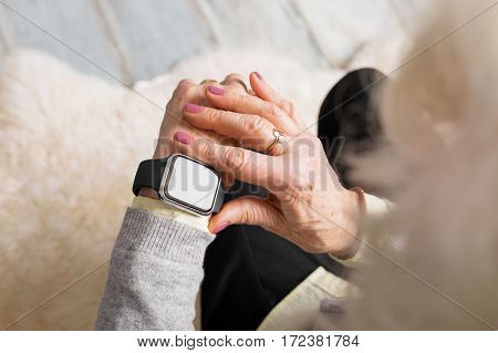 Old person using smart watch on her wrist