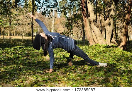 Beautiful Girl Doing Yoga At The Park At A Sunny Day.