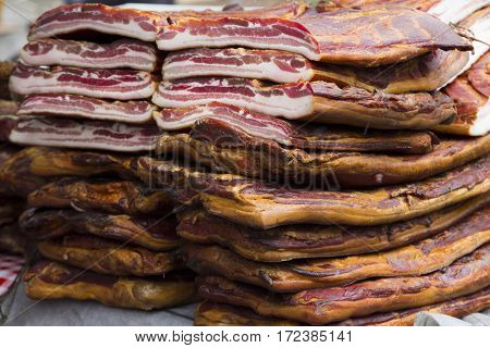 Home made smoked bacon in a street market selective focus and small depth of field