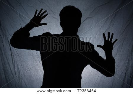 Shadow Of Man Behind Dark Fabric