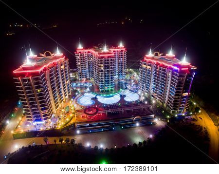 ALANYA, TURKEY - AUG 16, 2015: Three buildings of apartment complex Azura Park Residence with red light at night, aerial photo