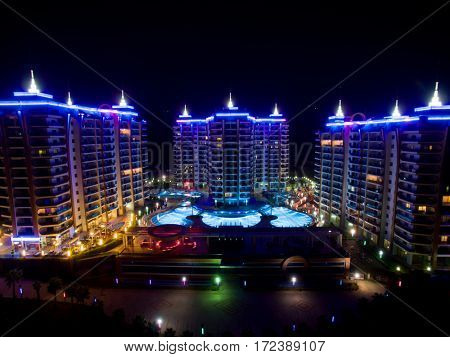 ALANYA, TURKEY - AUG 16, 2015: Three buildings of housing complex Azura Park Residence with color light at night, aerial photo