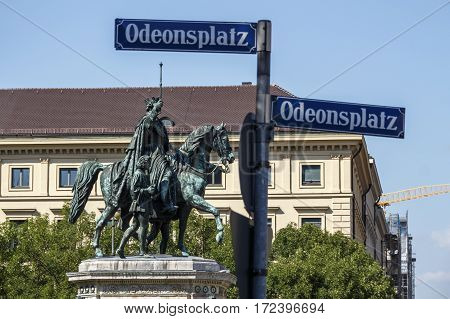 The monument Reiterdenkmal of King Ludwig I of Bavaria is located in Munich and the street sign of Odeonsplatz in front