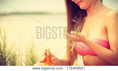 Skin protection in summer. Woman on beach using sun oil. Young beauty girl taking sunbath on sunny day. Holidays time.