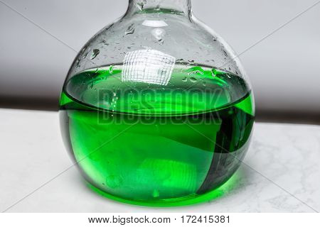 Green liquid in glass flask in laboratory