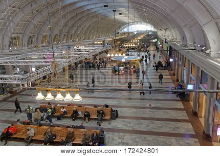 STOCKHOLM SWEDEN - MAY 05 2016: Lots of people waiting in the cental train station hall sitting on benches. May 05 2016 Stockholm Sweden