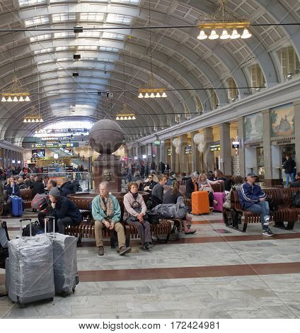 STOCKHOLM SWEDEN - MAY 05 2016: Lots of people waiting in the cental train station hall sitting on benches. May 05 2016 Stockholm Sweden