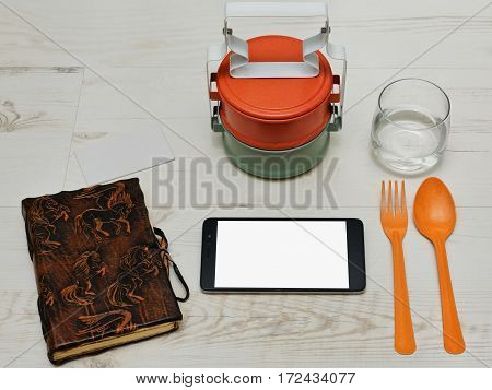 Lunch break with thai asian styled containers for meals tablet handmade diary and a glass of water