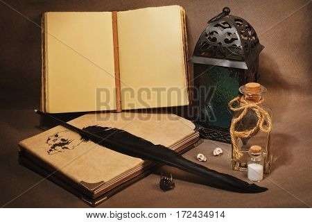 Mystical still life with vintage books with strange paintings old lantern antique pen wizard's ring and other witch's accessories