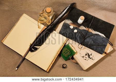 Workspace of ancient writer poet or alchemist - old books, charms, magic rings, vials.