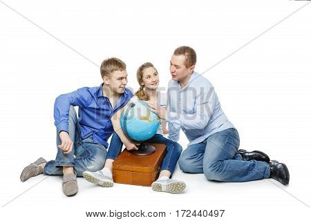 Beautiful teen boy and girl in casual clothes sitting on floor with father looking for something on the Earth globe. Isolated on white background. Copy space.