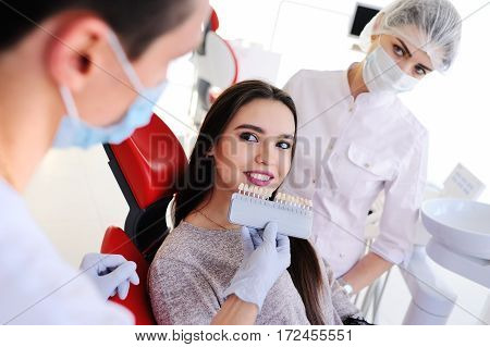 choose the color of the teeth. two dental pick the color of tooth enamel for the patient