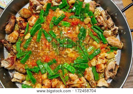 Paella from Spain recipe process ad vegetables green beans and tomato