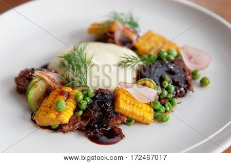 Pulled pork with grilled vegetables and potato mash, close-up