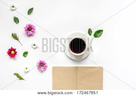 Froral flat lay with cup of coffee and craft notepaper on white background top view mockup