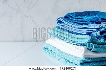 blue towels pile in housekeeping set on laudry gray background mock up
