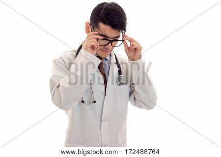 a young doctor in a white lab coat holding up hands for the glasses isolated on white