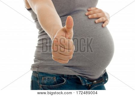 the midsection of a young pregnant woman who raised her hand forward and shows a close-up of a class is isolated on a white