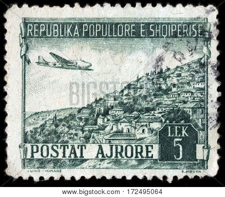 LUGA RUSSIA - FEBRUARY 7 2017: A stamp printed by ALBANIA shows airplane Douglas DC-3 over Yuno in Southern Albania circa 1950