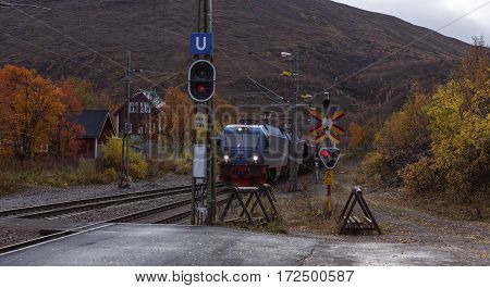 BJORKLIDEN, SWEDEN ON SEPTEMBER 20. An Iron Ore train pass the station on September 20, 2016 in Bjorkliden, Sweden. The train slow down around the station. Editorial use.