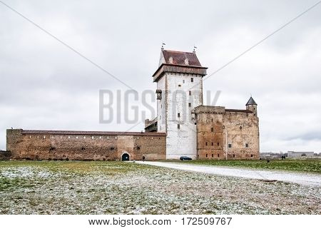 NARVA, ESTONIA - JANUARY 2, 2017: View of Hermann Castle Museum on the bank of The Narva (Narova) River. On the right side is Narva Hydroelectric Station
