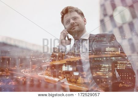 Low angle view of smart businessman talking on mobile phone against office building