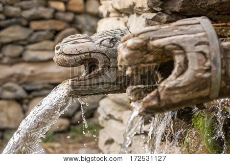 Wooden wall fountain in nepalese village in Annapurna Region, Nepal.
