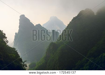 Photo of Huge Rock Mountain Silhouette with White Mist. Epic Mountain Landscape