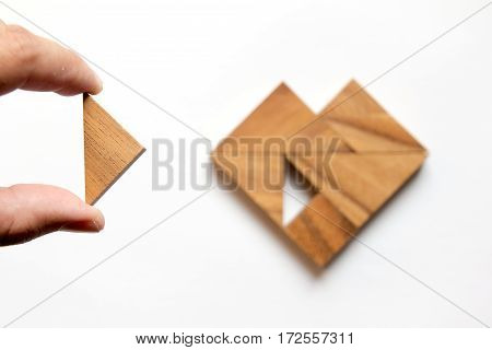 Man held piece of tangram puzzle to fulfill the heart shape on white background (Concept of love)