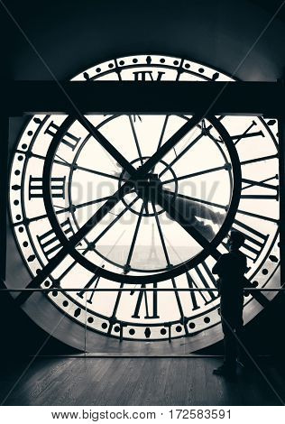 A tourist looking thrugh giant clock tower in Paris, France.