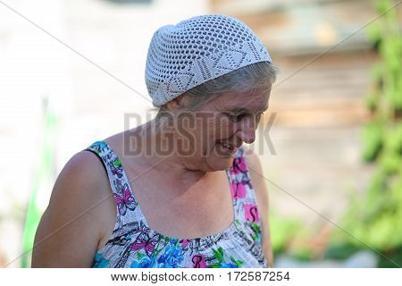 an elderly woman in the garden outdoors in dress