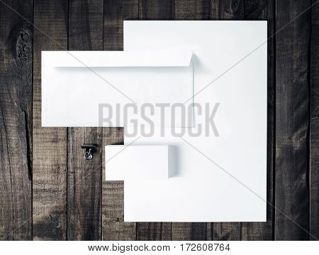 Blank stationery and corporate identity template Photo of blank letterhead business cards and envelope on vintage wooden table background. Responsive design mock up. Top view.