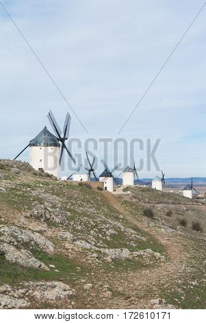 White old windmills on the hill near Consuegra (Castilla La Mancha Spain) a symbol of region and journeys of Don Quixote (Alonso Quijano) on cloudy day.