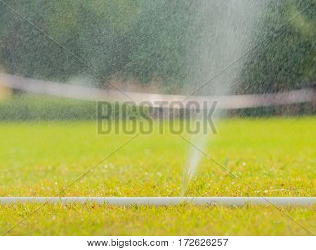Sprinkler watering the grass of the football field