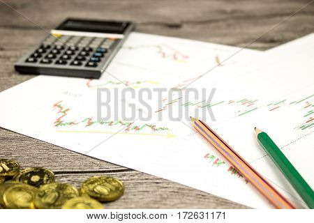 calculator, pencils and coins on graffica the Dow Jones on forex market at grey table