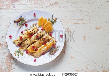 Thin crepes or pancakes with fresh pumpkin confiture, on a rustic wooden background, top view with copy space.