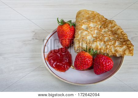 Pancakes With Strawberries On A Wooden Background