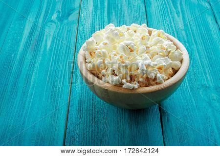 Popcorn In Wooden Plate On A Blue Background