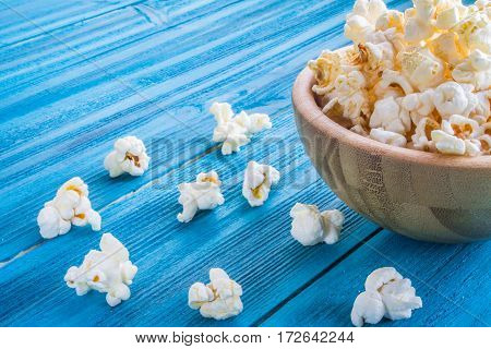 Popcorn In Wooden Plate On A Blue Background