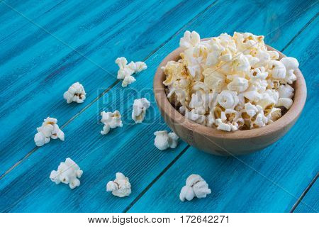 Popcorn In Wooden Plate On A Blue Background