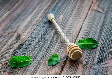 Spoon Of Honey And Mint Leaves On A Wooden Background