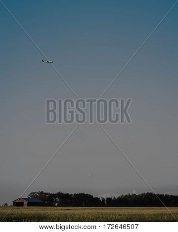 Plane flying above a farmers field near Devon Alberta