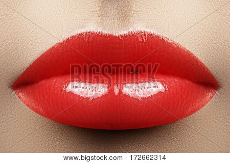 Cosmetics makeup and trends. Bright lip gloss and lipstick on lips. Closeup of beautiful female mouth with red juicy lipgloss makeup. Beautiful part of female face. Perfect clean skin