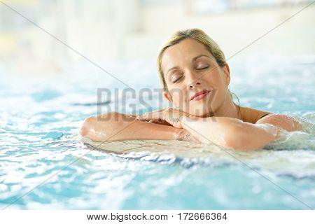 Beautiful blond woman relaxing in thalassotherapy thermal water