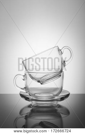 Two transparent glass cups on the white background